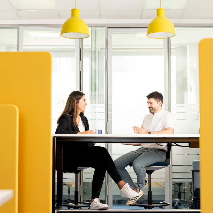 Two people talking to eachother in a divided room space