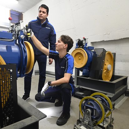 Kay Justus Kornatzki (vorn) und Michael Gostav Joran Gandolfo von TÜV NORD führen im Maschinenraum einer Aufzugsanlage Prüfungen durch Bildquelle: Henning Scheffen/TÜV NORD AG