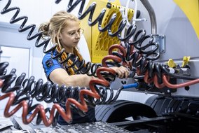  Eine TÜV NORD Mitarbeiterin arbeitet an den Anschlüssen eines LKWs