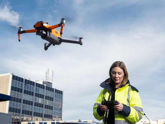 Woman with drone in front of TÜV NORD building