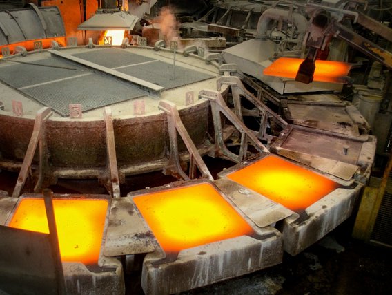 Flüssiges Kupfer erstarrt in den quadratischen Formen des Gießrades.