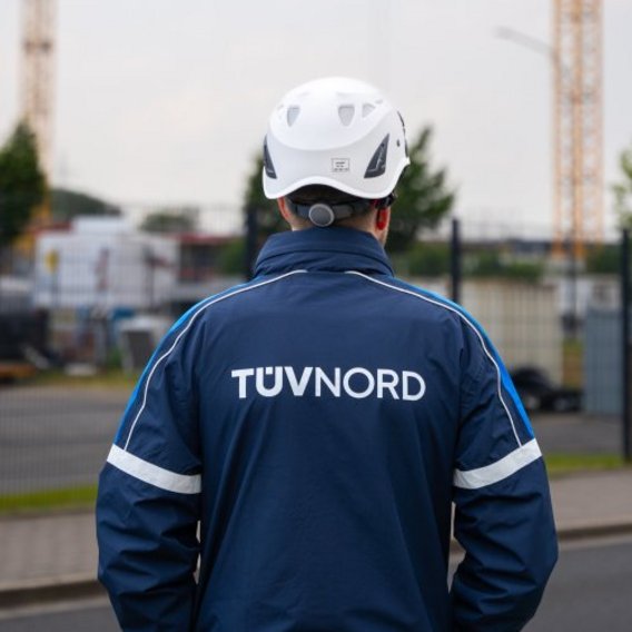 TÜV Prüfer schaut auf Baustelle