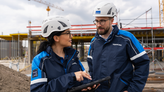 Two engineers talking in front of a building