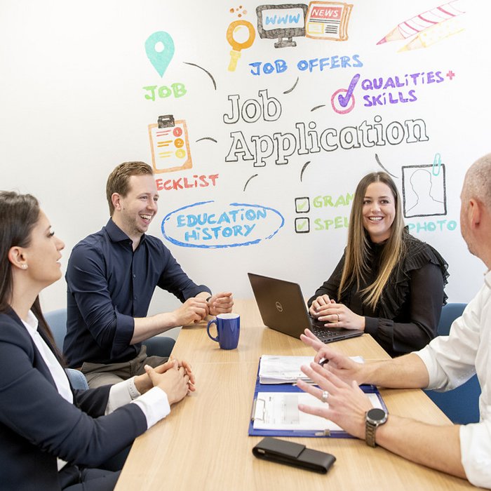 A mixed group of four people work together at a table
