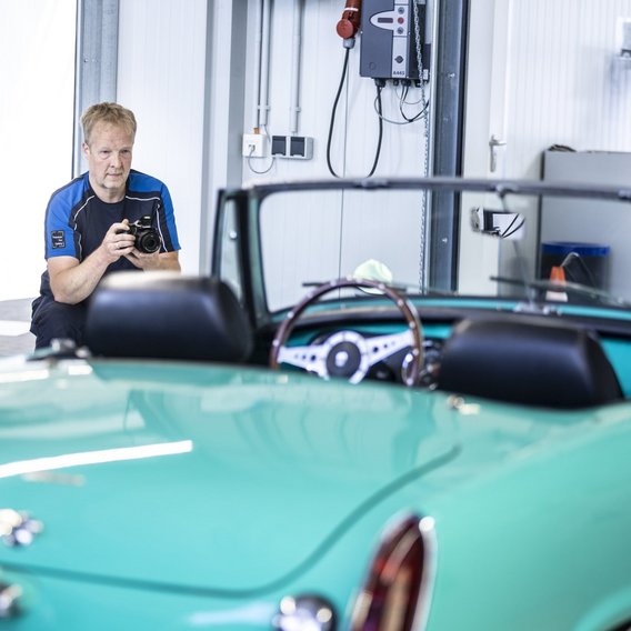 Prüfingenieur fotografiert Oldtimer an der TÜV NORD Station